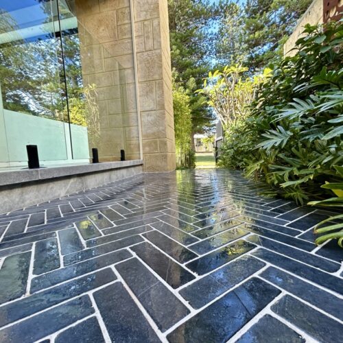 A black and white tiled walkway in front of a house.