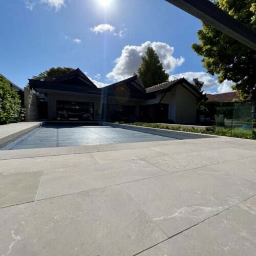 A swimming pool in a house with a stone patio.