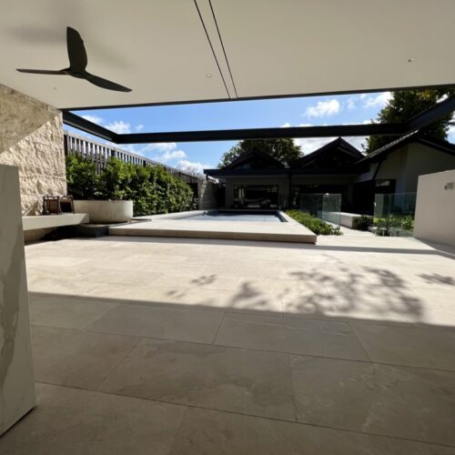 A modern home with a pool and a ceiling fan.