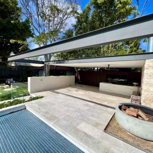 A modern backyard with a swimming pool and a fire pit.