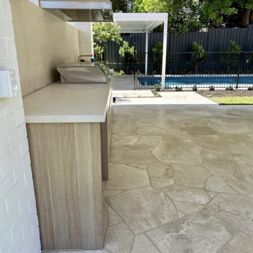 An outdoor kitchen with a stone counter top.