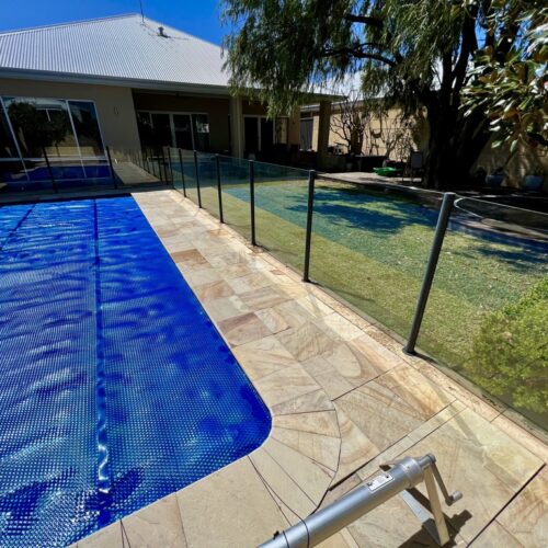 A swimming pool in a backyard with a fence.