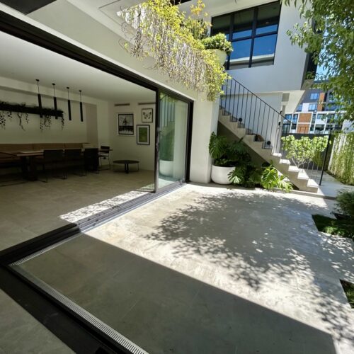 A modern house with a patio and a glass door.