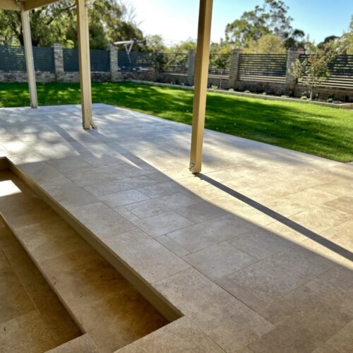 A patio with a fire pit and a grassy area.