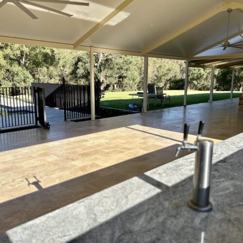 A covered outdoor area with a bar and a grill.