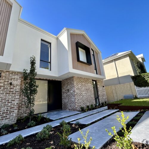 The exterior of a modern home with a driveway.