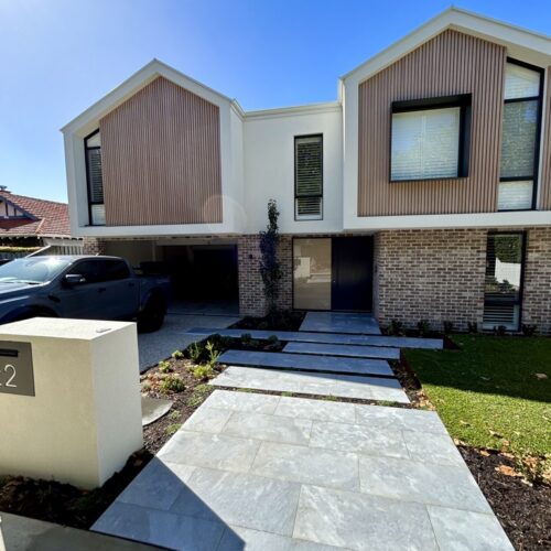 A modern house with a car parked in front of it.