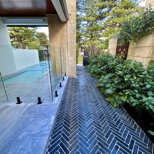 A black and white tiled walkway with a glass door.