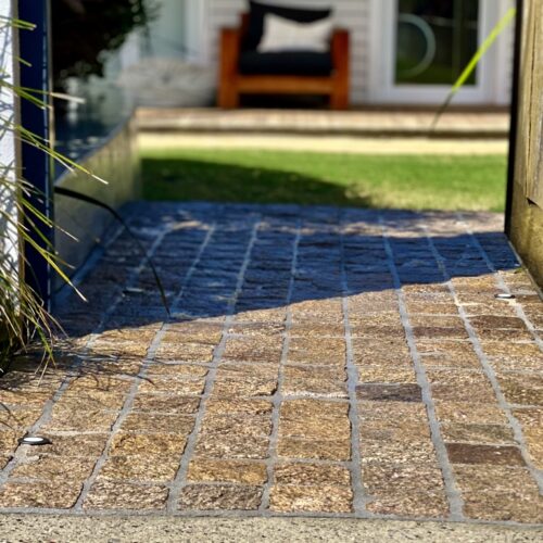 A brick walkway leading to a house.