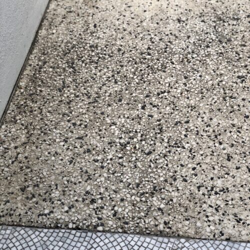 A concrete floor with a tiled pattern on it.