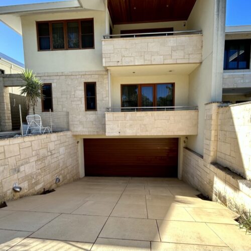 A driveway leading to a house with a garage.