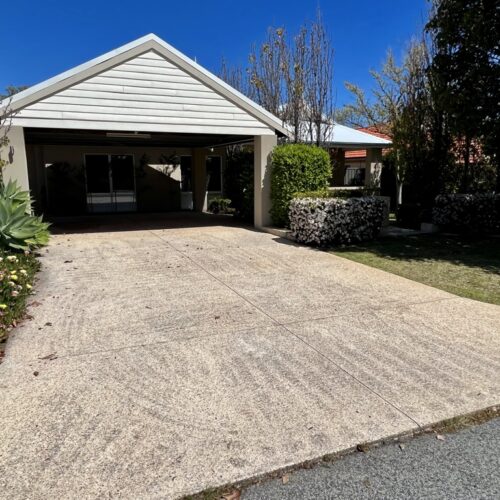 A driveway leading to a house with a garage.