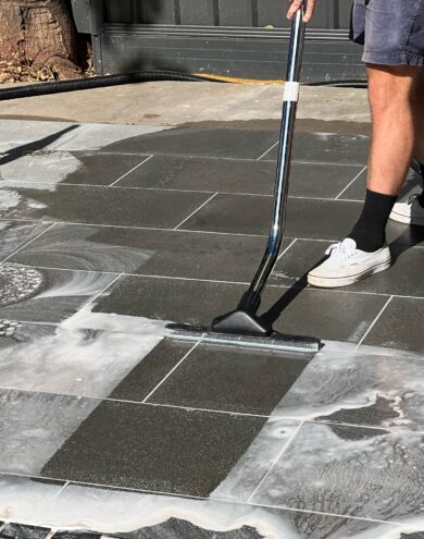 A man cleaning a tiled area with a mop.