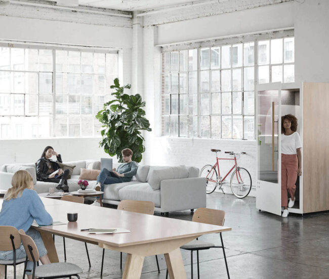 A group of people sitting around a table in an office.